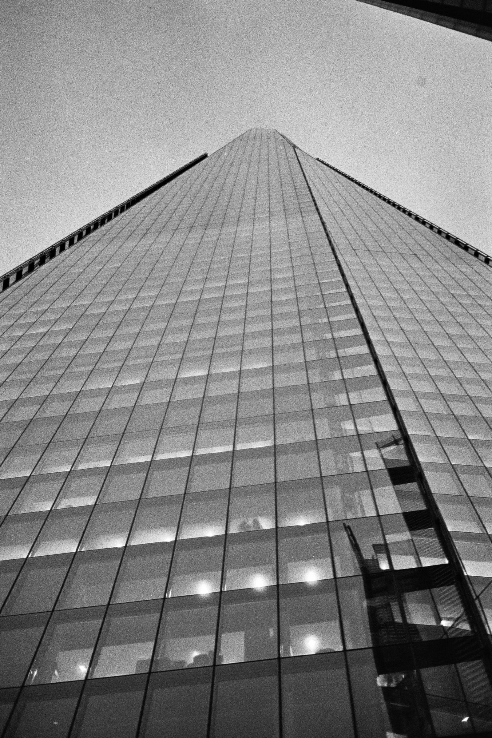 A black and white photograph of The shard, taken from the base looking up